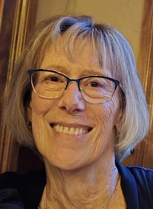 A woman with glasses smiling